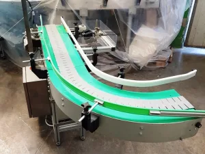 NASTRO TRASPORTATORE MOTORIZZATO A TAPPARELLE CON CURVA A 90° – MATERIAL HANDLING