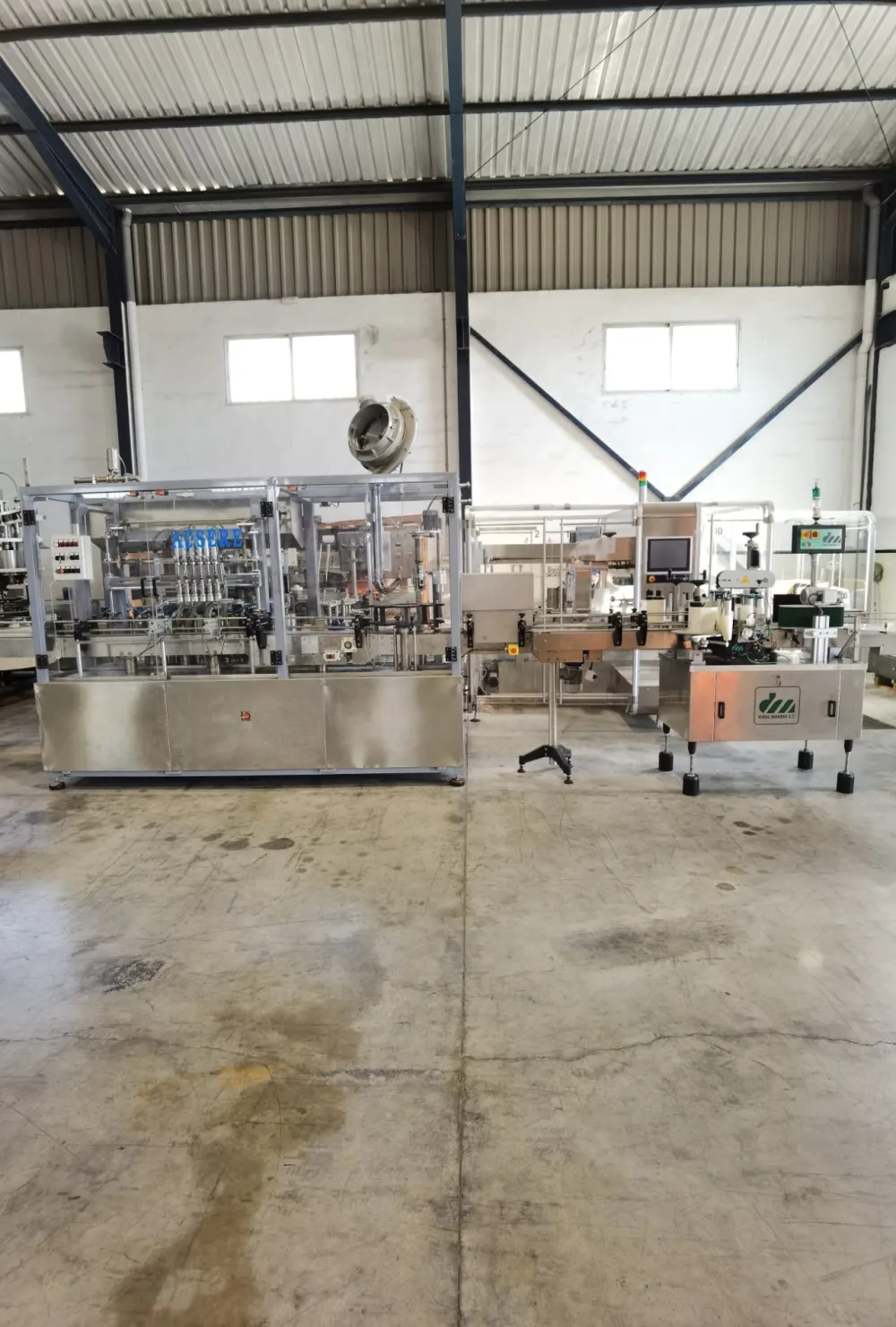 Linea de llenado y etiquetado con llenadora volumétrica Ausere de 6 pistones, taponadora Pilfer y etiquetadora autoadhesiva de 3 cabezales