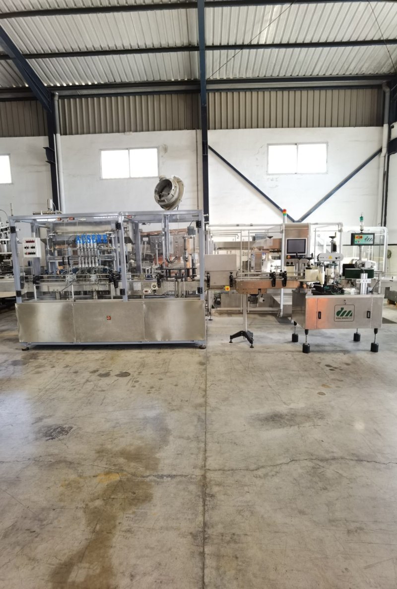 Linea de llenado y etiquetado con llenadora volumétrica Ausere de 6 pistones, taponadora Pilfer y etiquetadora autoadhesiva de 3 cabezales